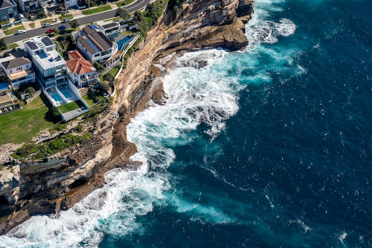 Homes atop ocean cliff face