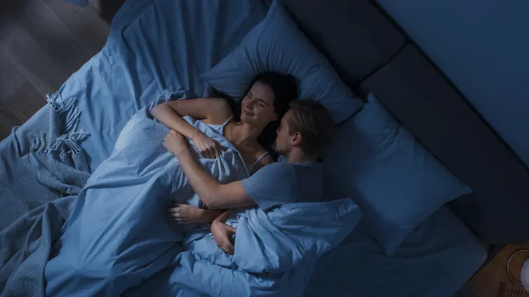 A couple snuggling in bed
