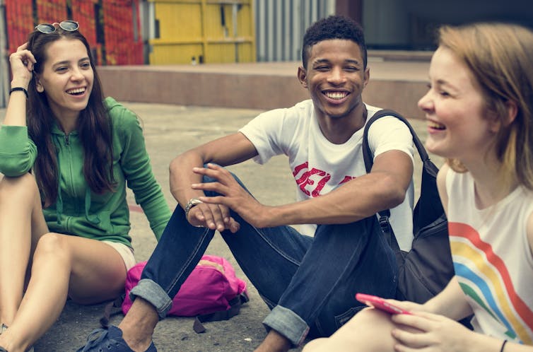 Group of young friends laughing about something.