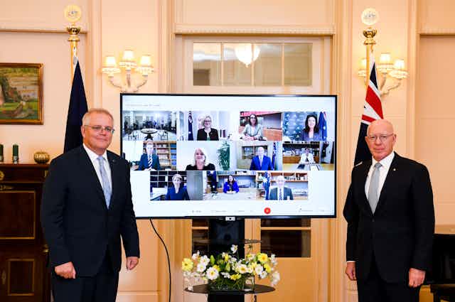 Scott Morrison and Governor-General David Hurley stand in front of a screen, displaying Morrison's newly appointed cabinet