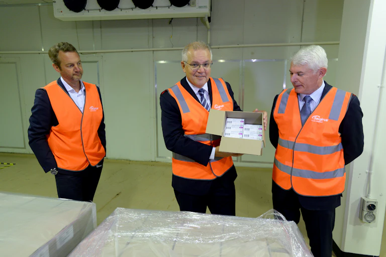 Prime Minister Scott Morrison holding a box full of COVID-19 vaccines