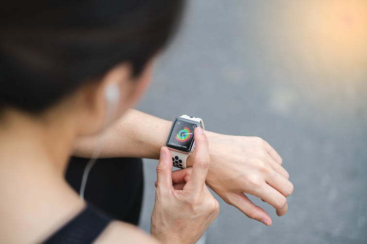A woman controls her Apple watch.