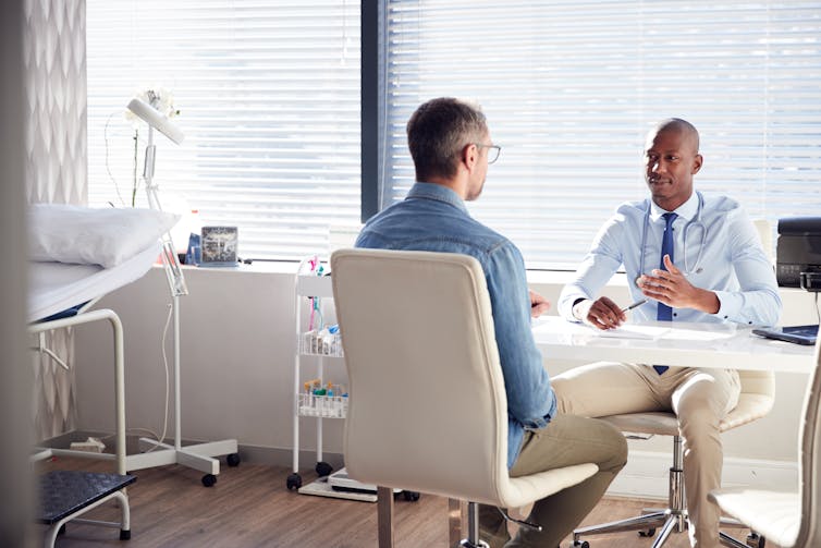 A man consults with a doctor in a bright office.