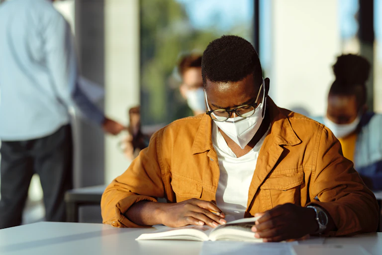 Student studies a book in a classroom