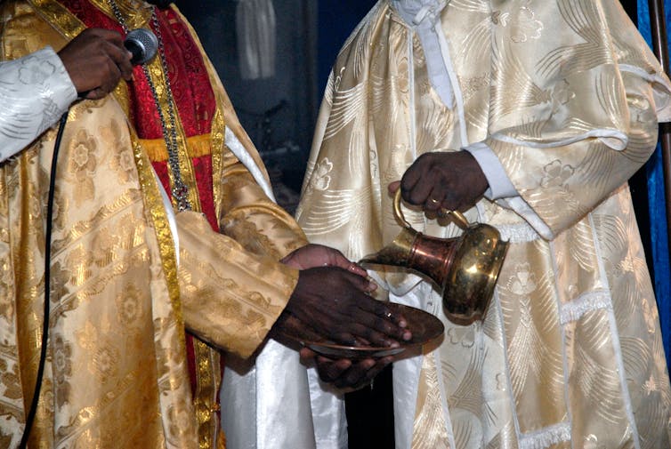 Black clergy prepare communion.