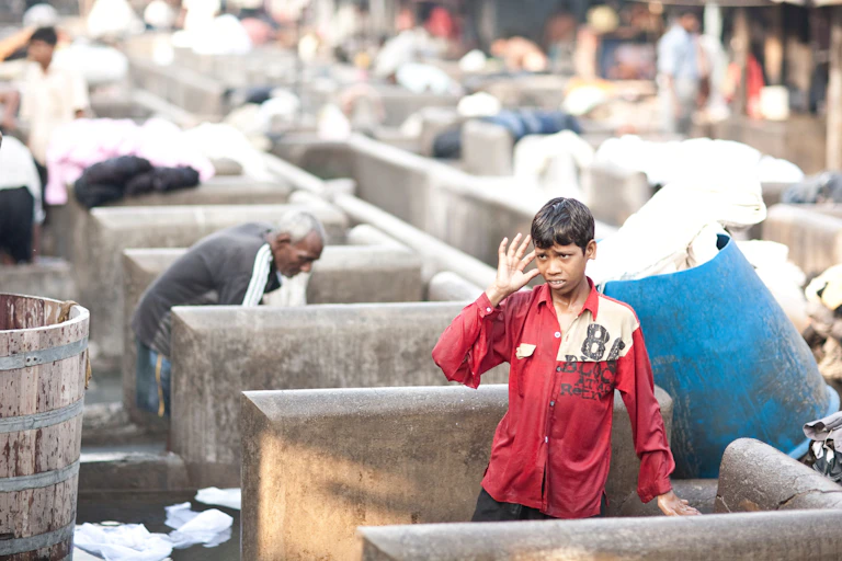 A young Dhobi at work at the Dhobi Ghat, in Mumbai India. The Dhobi are an caste group found in Pakistan and India who specialize in washing clothes.