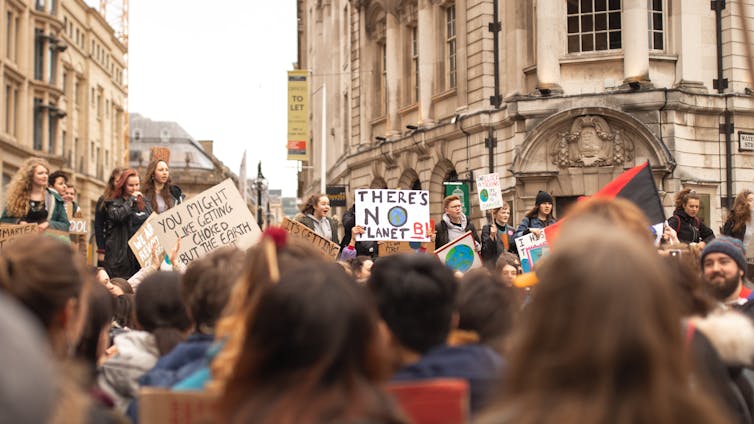 Crowds of young people hold placards.