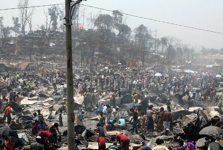 People looking through burned structures.
