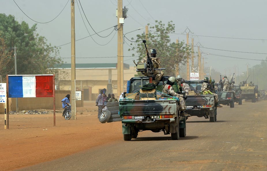 Soldiers sitting on gun-mounted vehicles while patrolling the streets