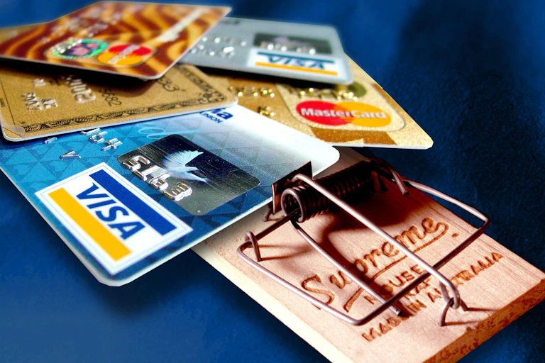Several credit cards laid out on a mouse trap.