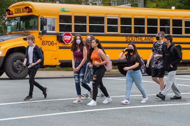 Students walk near a bus.