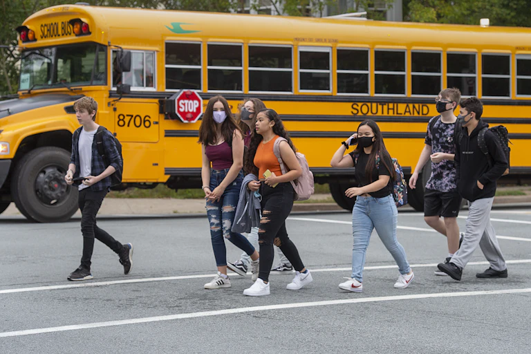 Students walk near a bus.