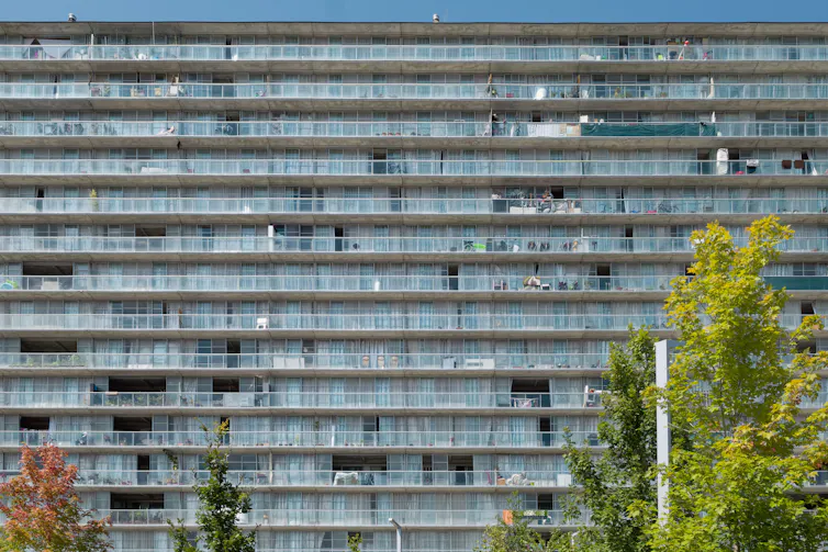 A high-rise housing estate with balconies and trees