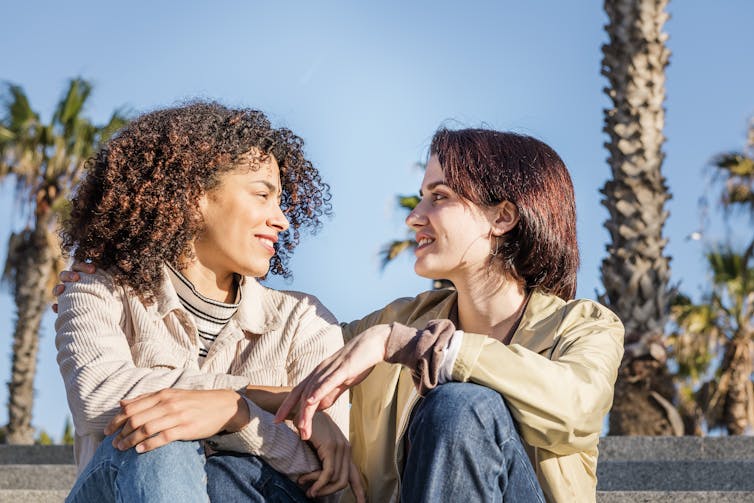 Queer couple smiling at each other