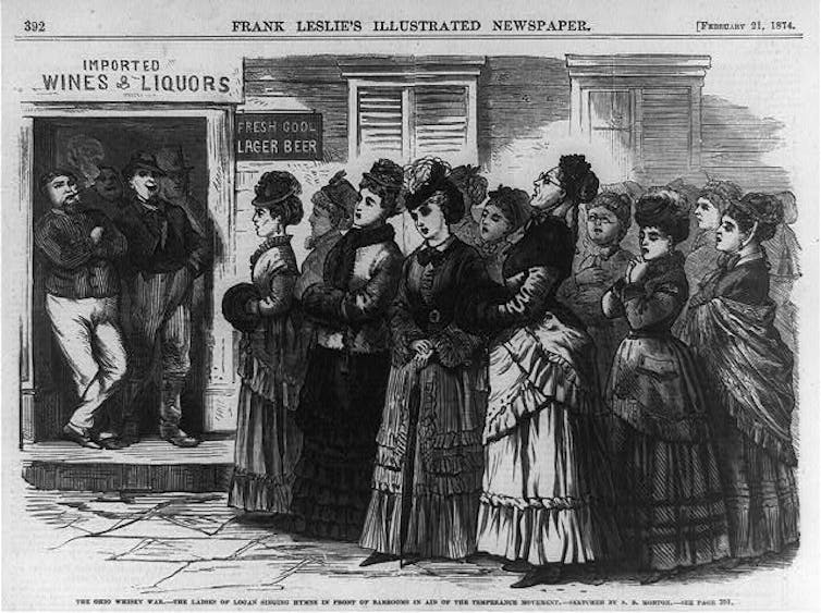 A woodcut illustration of a group of women outside a bar, where two men lean against the doorway