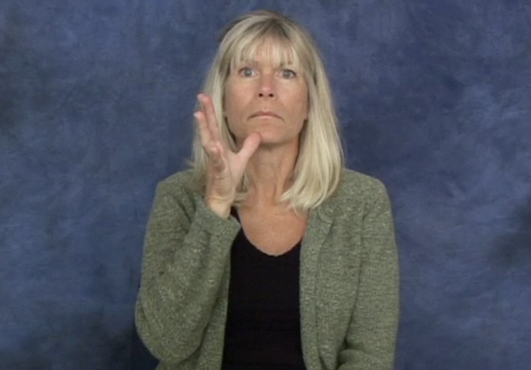 A woman holding her hand open with her thumb touching her chin.