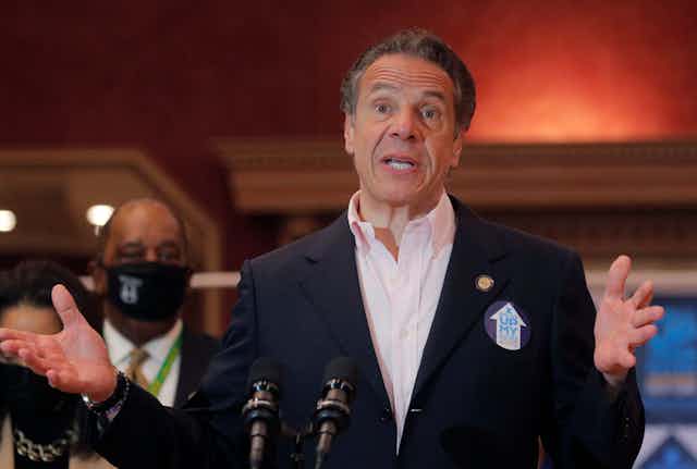 New York Gov. Andrew Cuomo speaking and gesticulating with his hands at a public gathering
