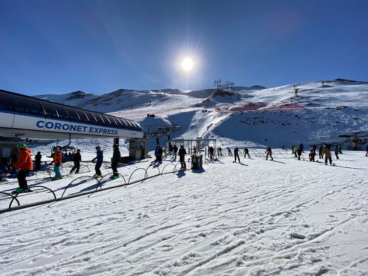 Skiers on mountain skifield in sunlight