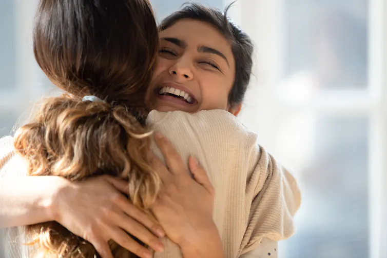 Two people hugging, one with their back to the camera.