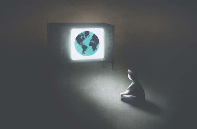 Illustration of a child sitting on the floor in the dark, watching a TV set that has the world on it 