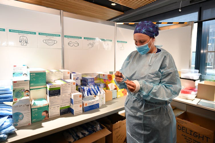 A health-care worker prepares to administer a COVID test.