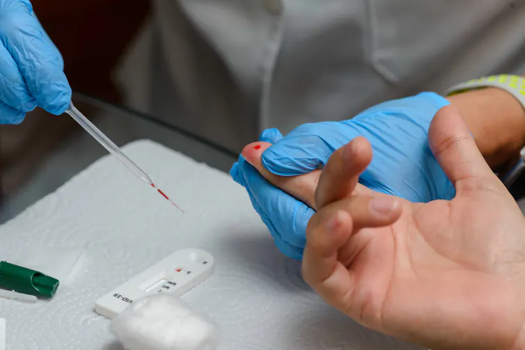 A medical professional administering an antibody lateral flow test