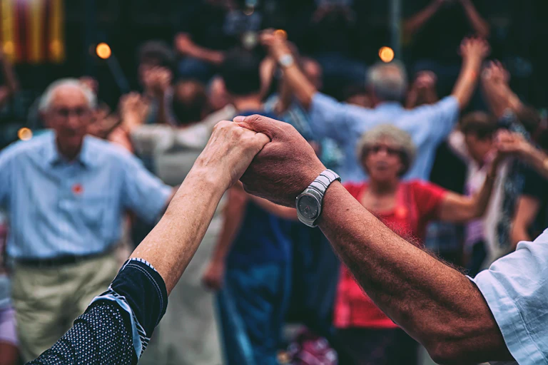 personas mayores bailan una sardana en la Plaza Nova de Barcelona.