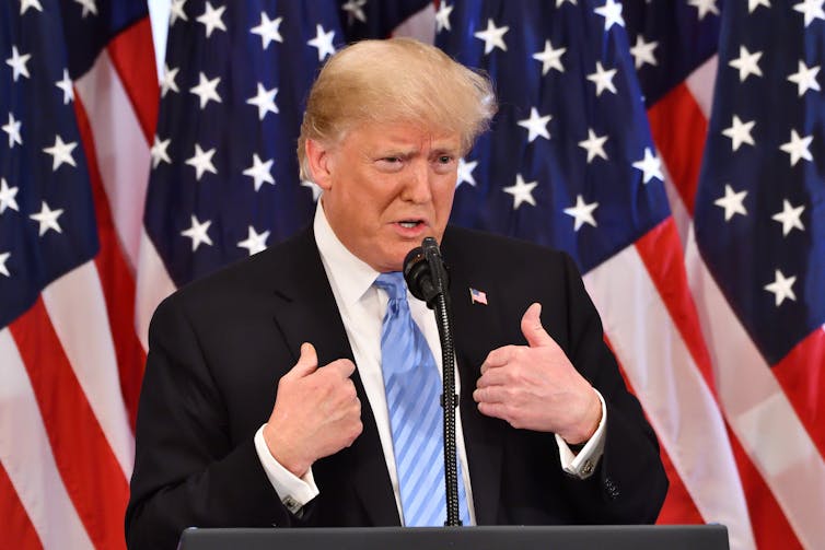 Donald Trump against a stars and stripes backdrop.