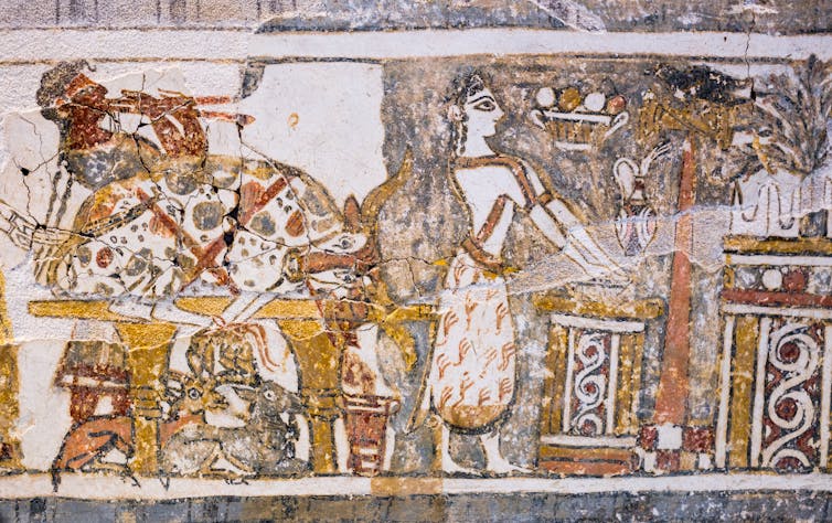 Priestess with hands outstretched over shallow bowl placed on an altar, to wash them with jug placed nearby.