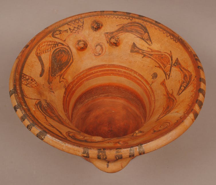 Clay hand washing bowl with fish and birds painted on the interior.