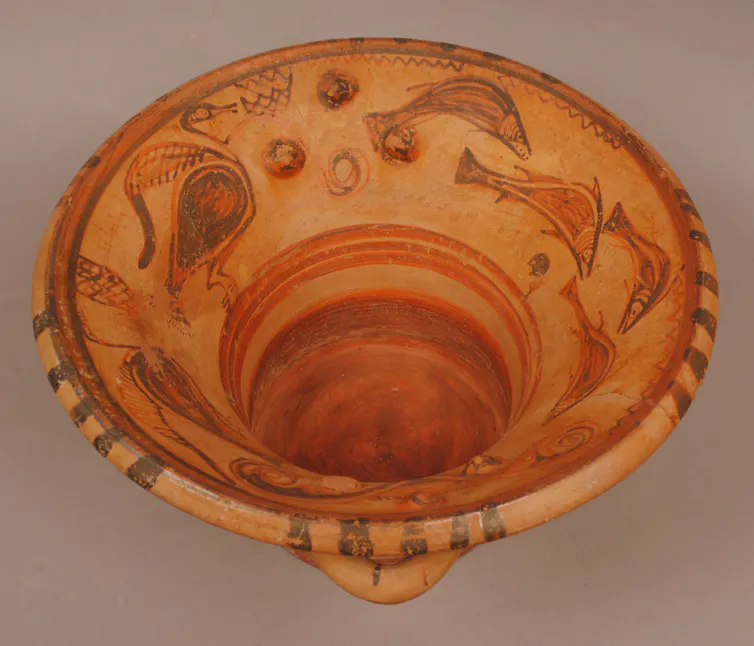 Clay hand washing bowl with fish and birds painted on the interior.
