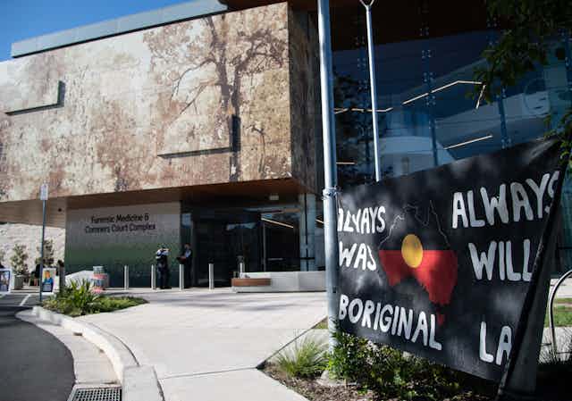 A courthouse with a banner out the front that reads 'Always was, always will be Aboriginal land'
