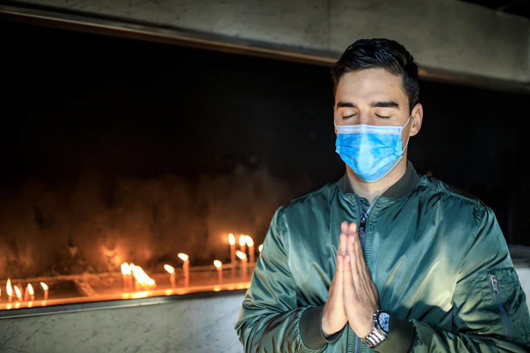A man holding his hands together in prayer.