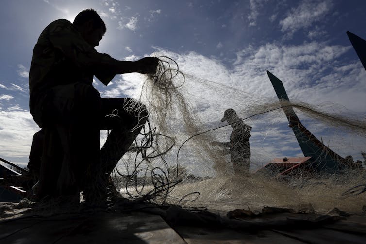 Men handle fishing nets