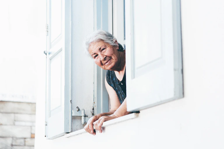 Old woman looking out of care home window