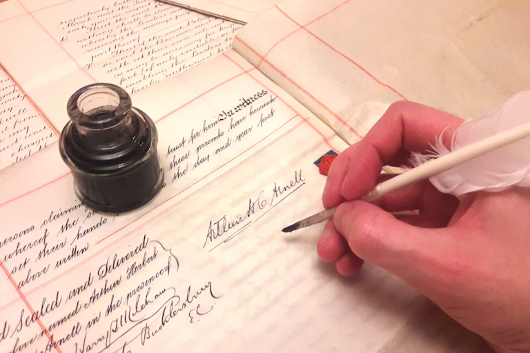 Signing a legal document with ink and quill.