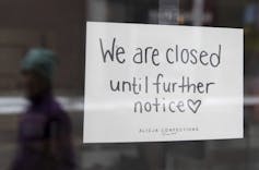 A sign on a store window says it's closed until further notice.