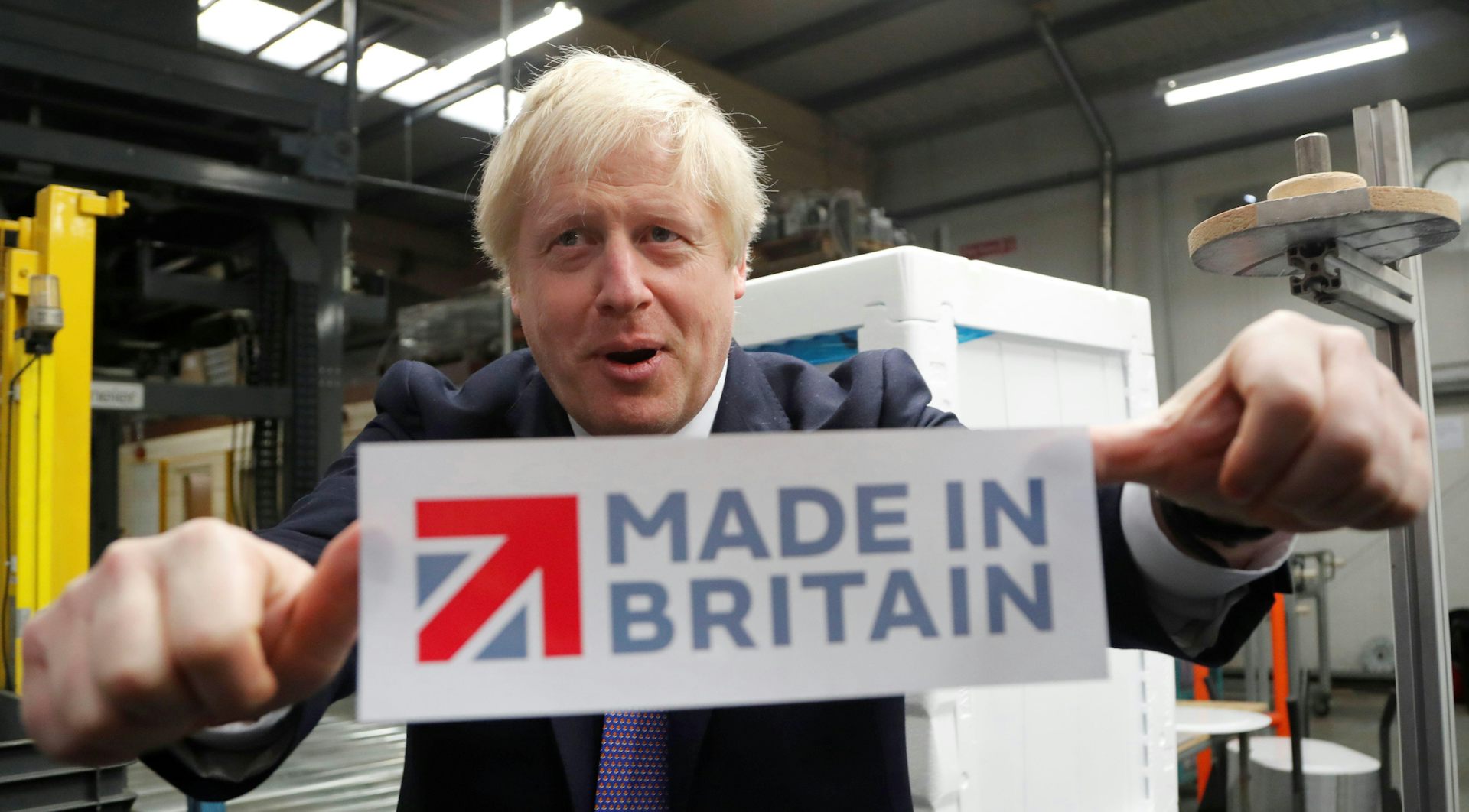 Boris Johnson sticking a 'Made in Britain' sticker on a window.