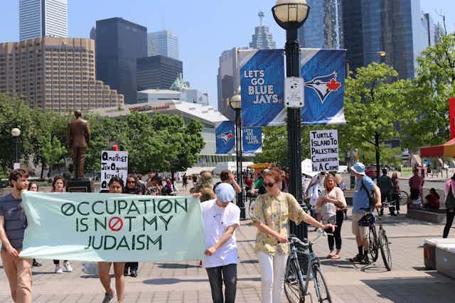People carry a banner reading Occupation is not my Judaism.