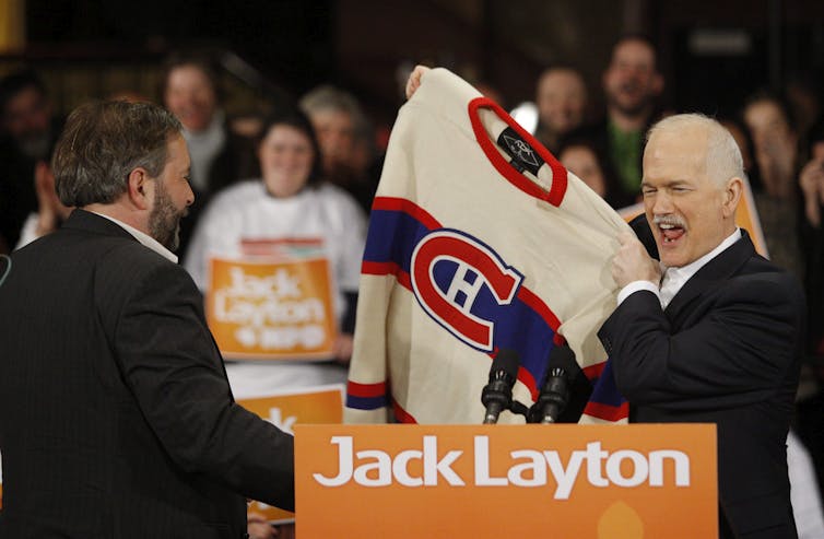 Thomas Mulcair et Jack Layton tenant un chandail du club de hockey Canadien