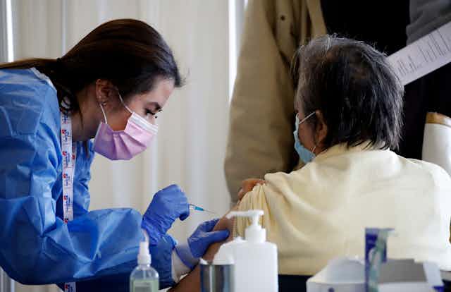 A nurse vaccinating a woman