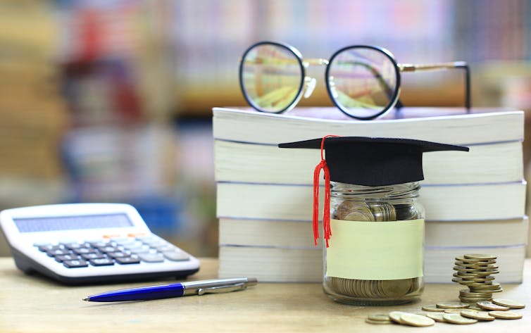 A pair of eye-glasses on top of a stack of three books.