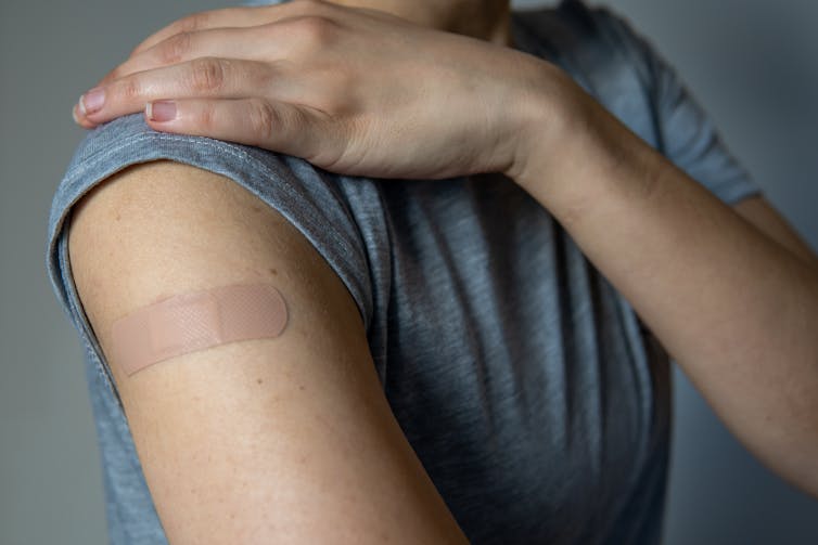 An arm with a bandaid on the upper arm.