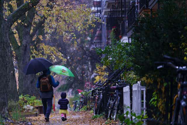 A man and child walk in the rain