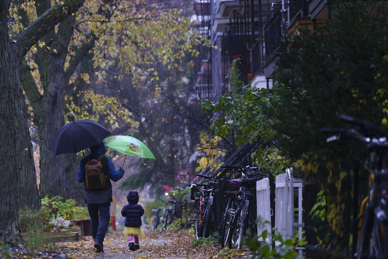 A man and child walk in the rain
