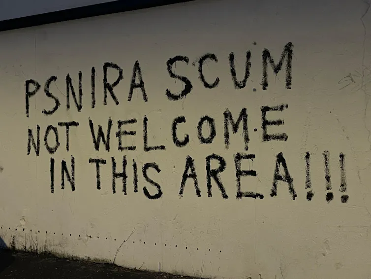Graffiti in Belfast reading 'PSNIRA scum not welcome in this area'.