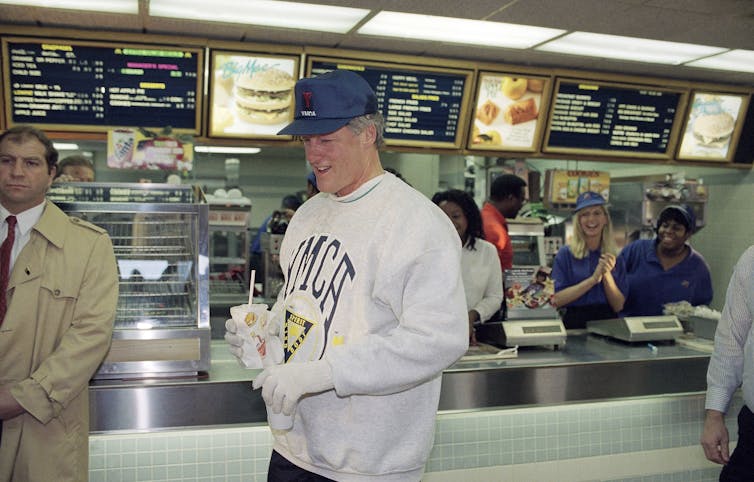 Bill Clinton holding a coffee in one hand and a cold drink in another at a McDonald's restaurant in downtown Little Rock, Arkansas, in 1993.