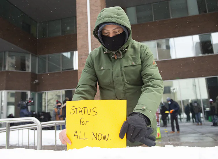 Man puts sign in snow that reads 'status for all'