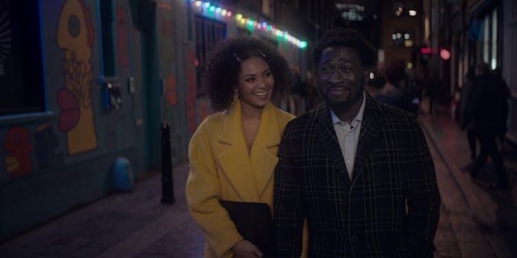 A couple walks down a street on a date.