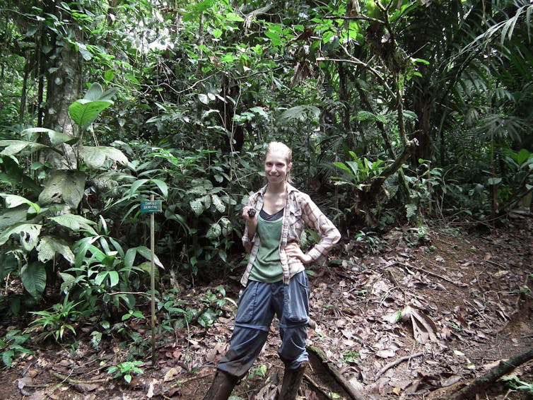 Woman standing in the middle of a rainforest.